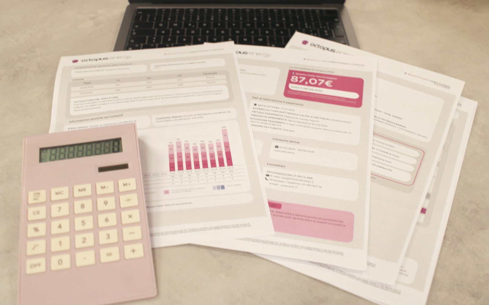 Bills, calculator, and laptop on a desk